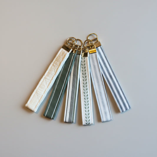 Set of keychains with striped straps on a wooden surface